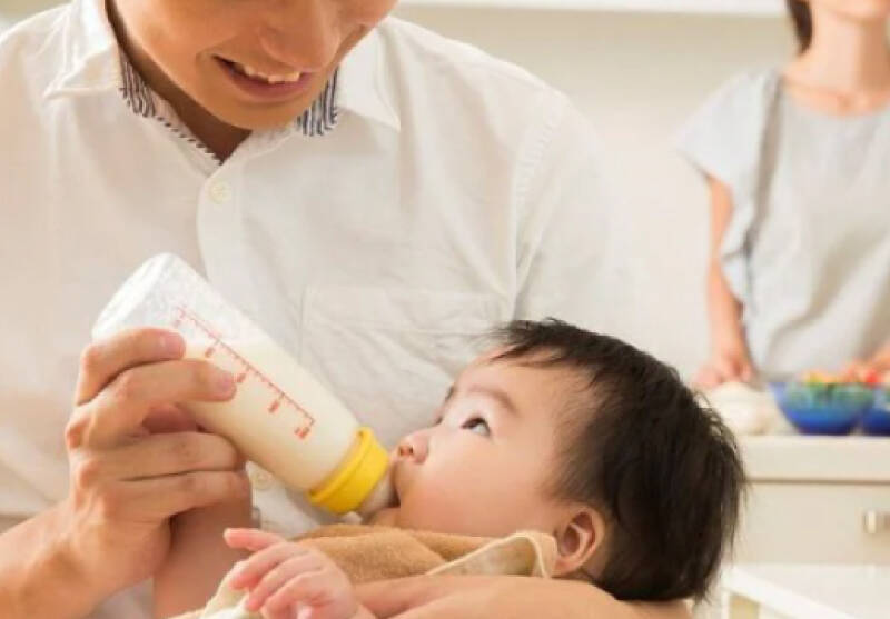 赤ちゃんにミルクを飲ませている写真